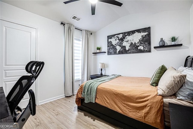 bedroom with baseboards, visible vents, a ceiling fan, vaulted ceiling, and light wood-style floors