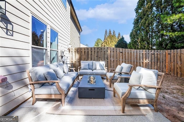 view of patio / terrace with an outdoor living space with a fire pit and fence