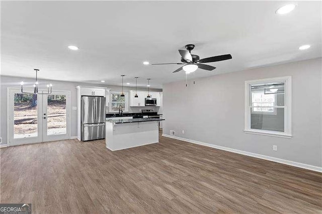 kitchen featuring a sink, white cabinetry, baseboards, appliances with stainless steel finishes, and dark wood-style floors