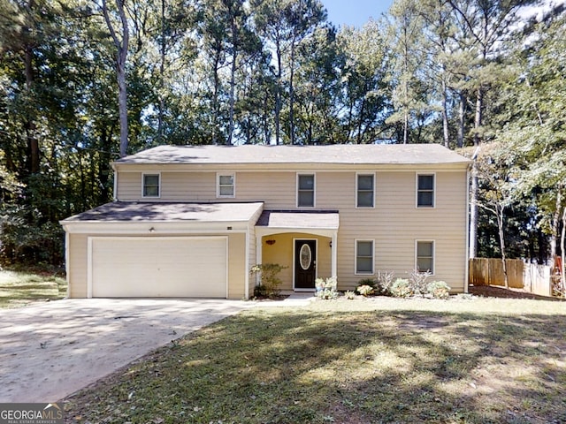 view of front facade featuring a garage, driveway, a front lawn, and fence