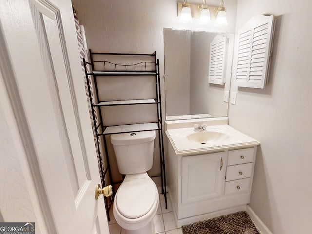 bathroom featuring toilet, tile patterned floors, baseboards, and vanity