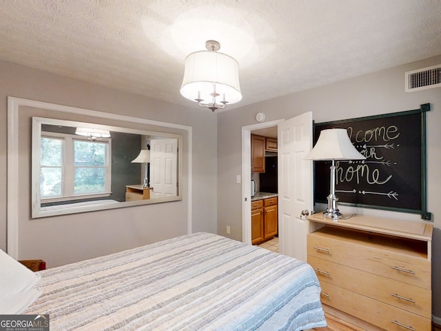 bedroom featuring visible vents and a textured ceiling