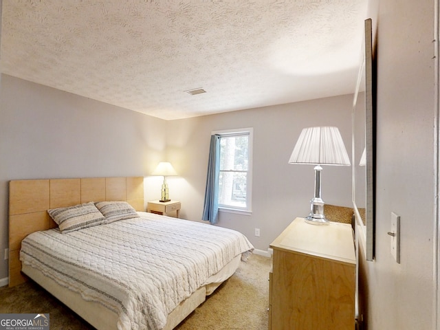 carpeted bedroom with baseboards, visible vents, and a textured ceiling