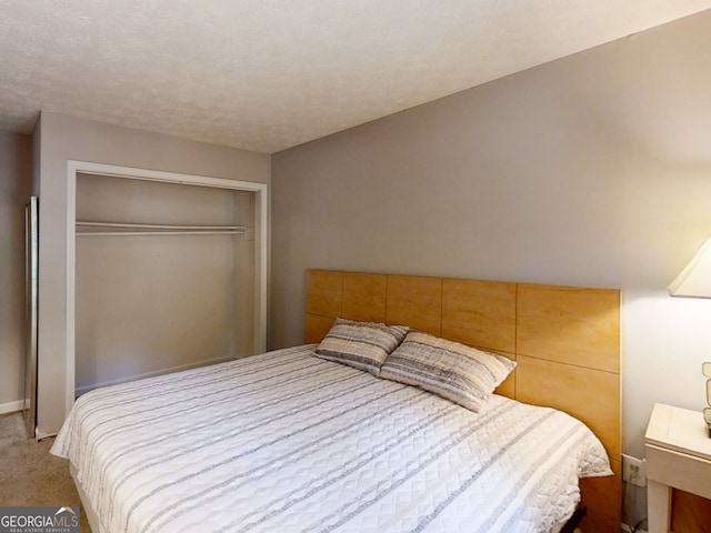 carpeted bedroom featuring a textured ceiling and a closet