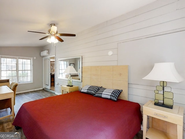 bedroom featuring baseboards, a ceiling fan, dark wood-style flooring, and an AC wall unit