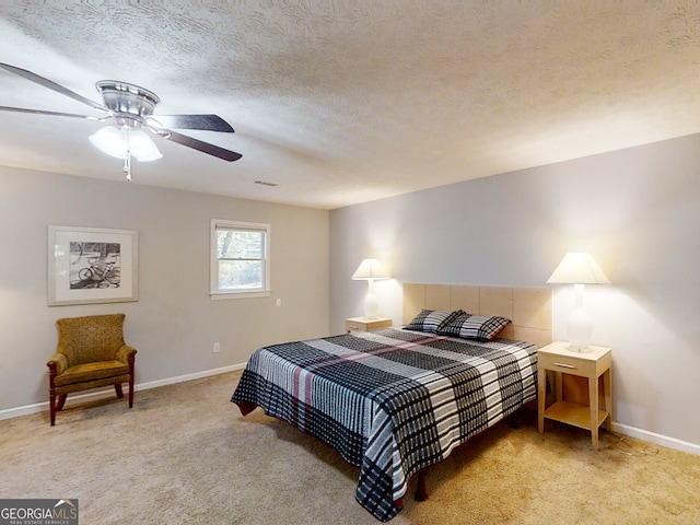 bedroom featuring visible vents, light carpet, a textured ceiling, and baseboards