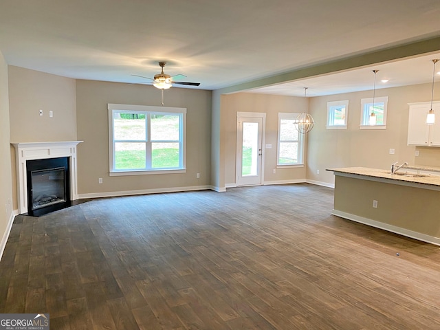 101 Westminster Ct, Winder, GA 30680 - unfurnished living room with dark wood-style floors, a ceiling fan, and a glass covered fireplace