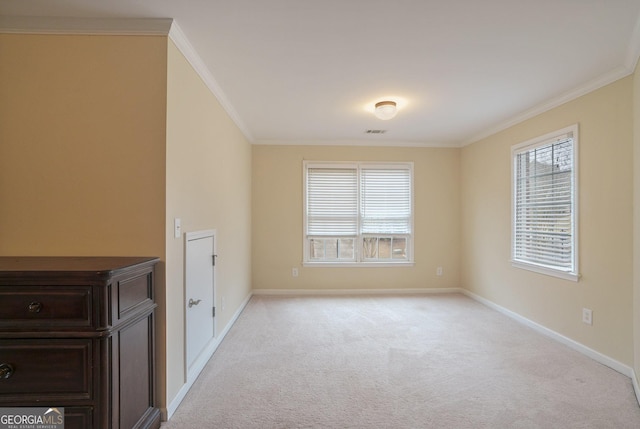 unfurnished room with light colored carpet, crown molding, visible vents, and baseboards