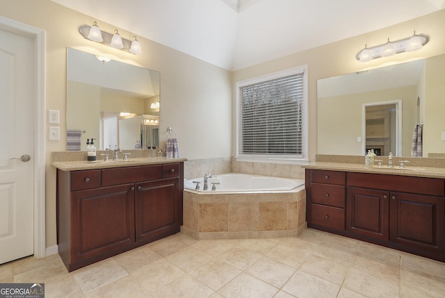 bathroom with a bath, two vanities, and a sink