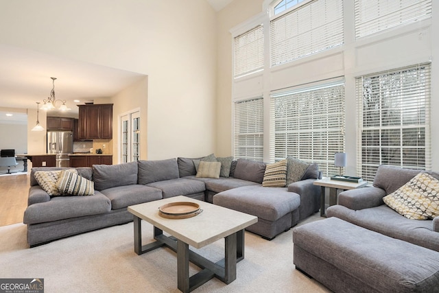 living area featuring a chandelier and a towering ceiling