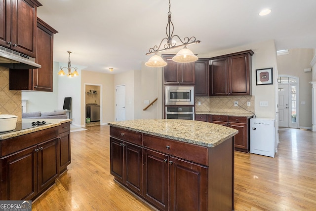 kitchen with stainless steel appliances, hanging light fixtures, dark brown cabinets, and a kitchen island