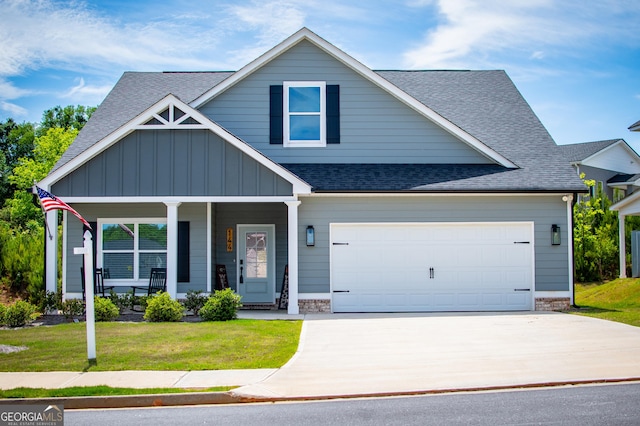 view of front of home featuring a shingled roof, concrete driveway, a front yard, board and batten siding, and a porch
