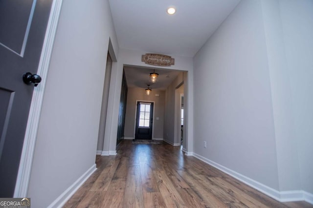 doorway featuring wood finished floors and baseboards