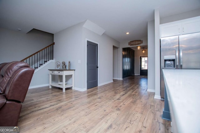 living room featuring light wood-style floors, stairs, recessed lighting, and baseboards