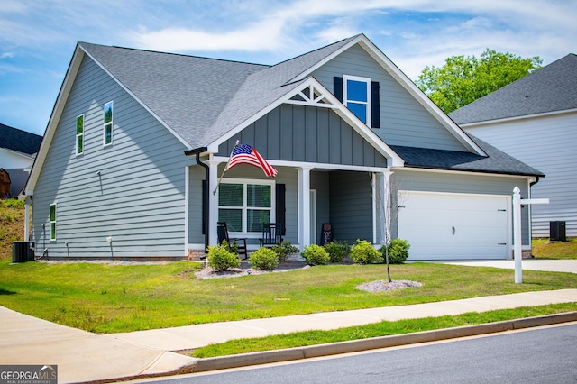 view of front of property featuring covered porch, board and batten siding, cooling unit, a front lawn, and roof with shingles