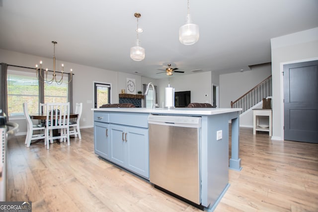 kitchen with stainless steel dishwasher, open floor plan, light wood-style flooring, pendant lighting, and a chandelier