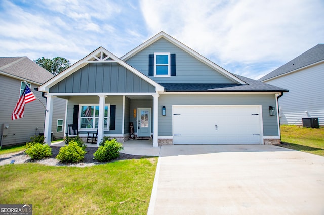 view of front of house with a porch, board and batten siding, central AC, driveway, and a front lawn