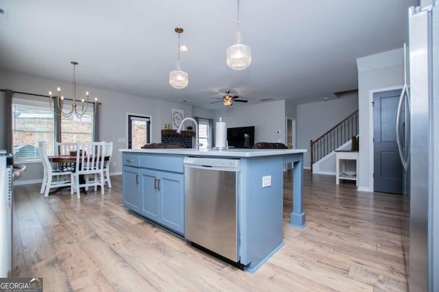 kitchen with appliances with stainless steel finishes, open floor plan, ceiling fan, light wood-type flooring, and a chandelier