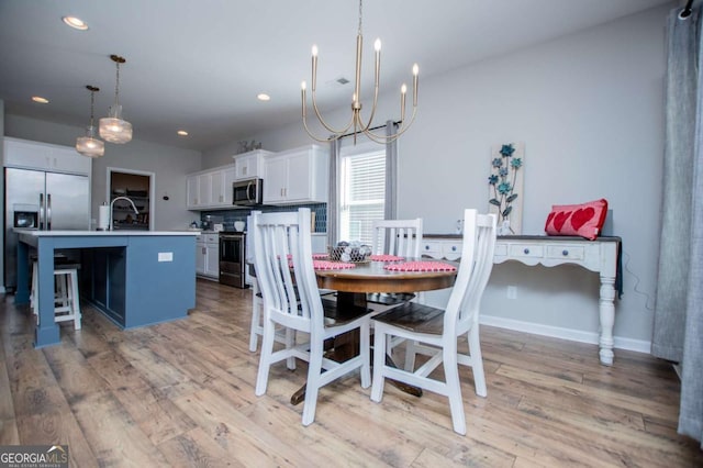 dining room featuring a chandelier, light wood finished floors, recessed lighting, and baseboards