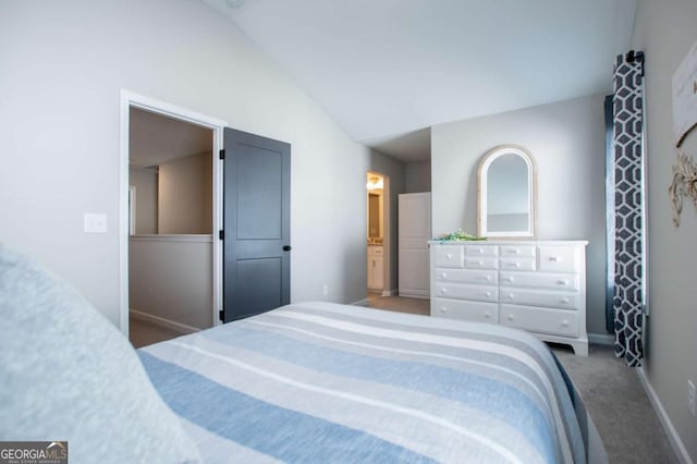 bedroom with carpet, baseboards, vaulted ceiling, and ensuite bath