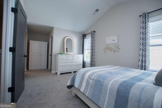 carpeted bedroom featuring vaulted ceiling and multiple windows