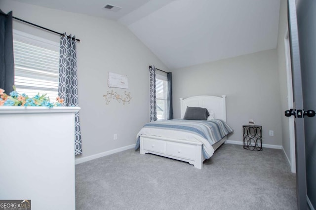 carpeted bedroom with lofted ceiling and baseboards
