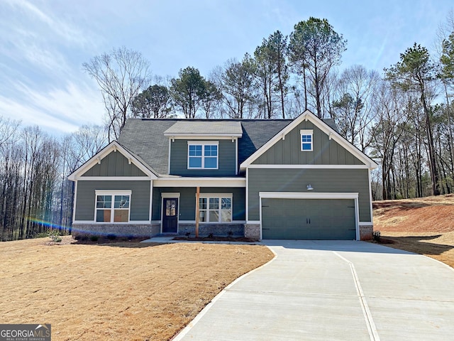 craftsman house with a garage, brick siding, board and batten siding, and driveway