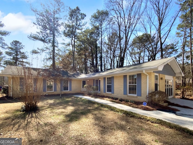 ranch-style house featuring brick siding and a front lawn