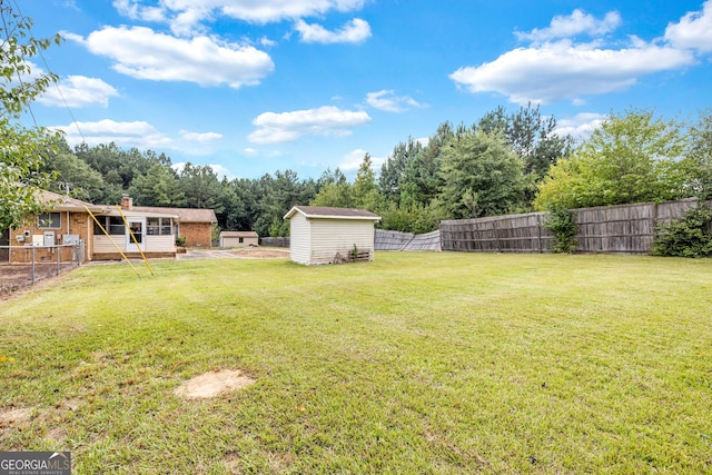 view of yard featuring a storage unit, an outdoor structure, and a fenced backyard