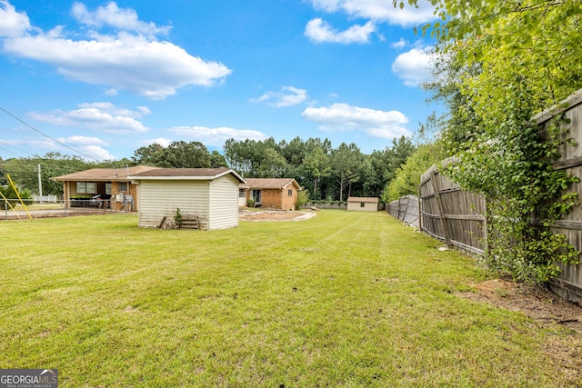 view of yard with an outbuilding, a storage shed, and a fenced backyard