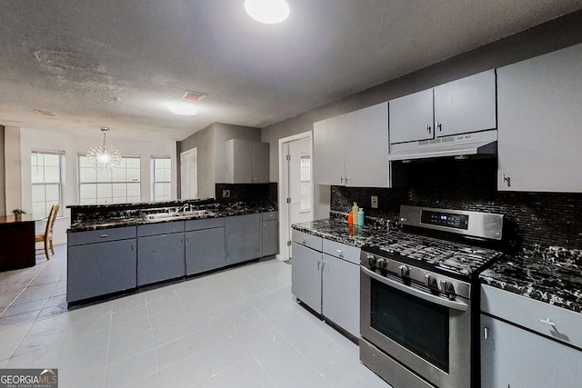 kitchen featuring visible vents, hanging light fixtures, gray cabinetry, gas range, and under cabinet range hood