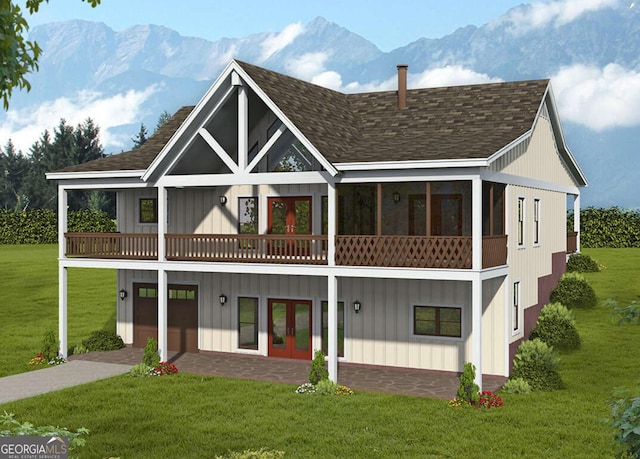 rear view of house with a mountain view, a garage, a shingled roof, a yard, and french doors