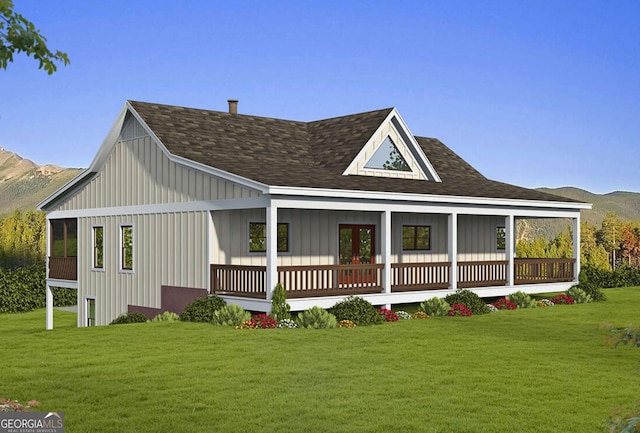 back of house with a lawn, board and batten siding, and a mountain view