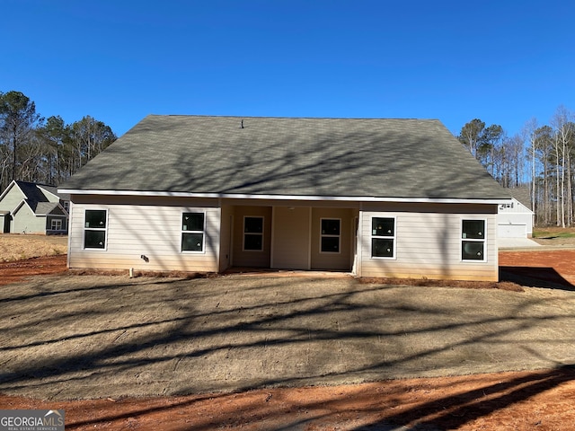 rear view of property featuring a lawn