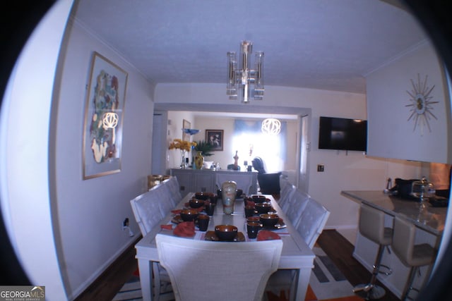 dining space with baseboards, wood finished floors, and crown molding