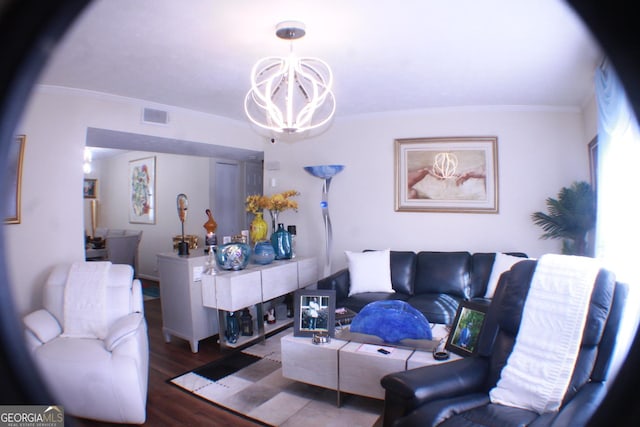 living room with ornamental molding, wood finished floors, visible vents, and a notable chandelier