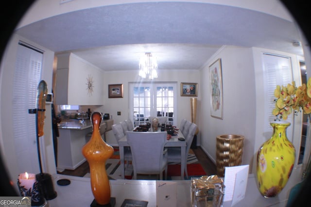 dining room featuring ornamental molding, wood finished floors, and an inviting chandelier