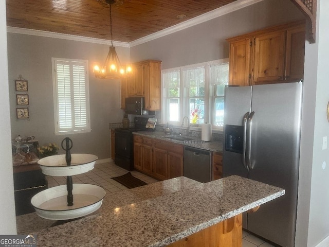 kitchen featuring stainless steel appliances, brown cabinetry, a sink, and a peninsula