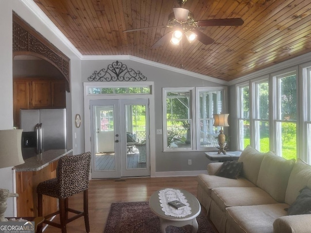 interior space with vaulted ceiling, french doors, wood ceiling, and a ceiling fan