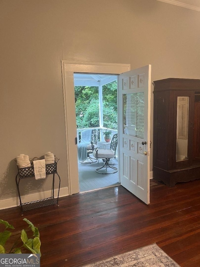 doorway featuring dark wood-style floors and baseboards