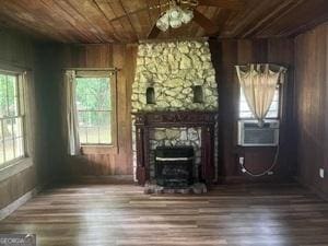 unfurnished living room with a wealth of natural light, wooden ceiling, a fireplace, and wood finished floors