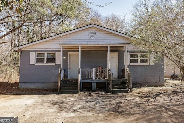 view of front facade featuring concrete block siding and a porch