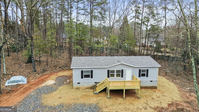 view of front facade featuring a deck, driveway, and crawl space