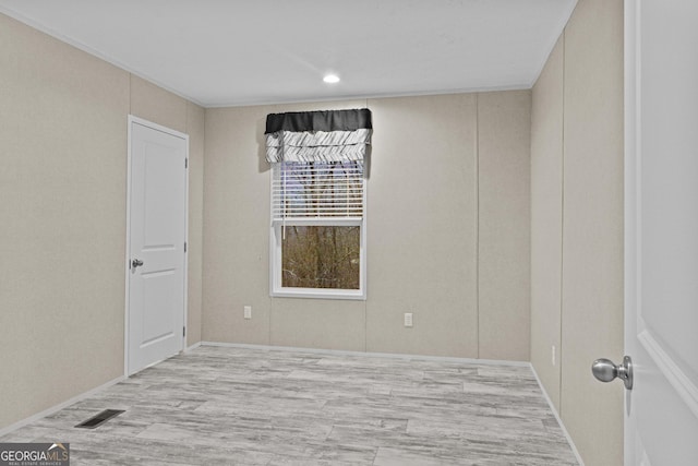 unfurnished room featuring light wood-style flooring and visible vents