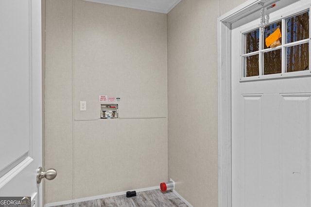 clothes washing area featuring laundry area, baseboards, washer hookup, and wood finished floors