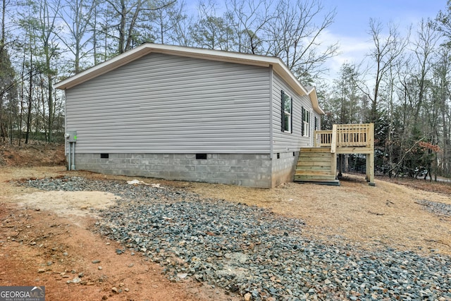 view of property exterior featuring crawl space and a deck