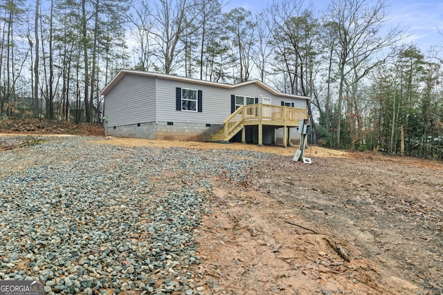 view of front of property featuring stairway, crawl space, and a wooden deck