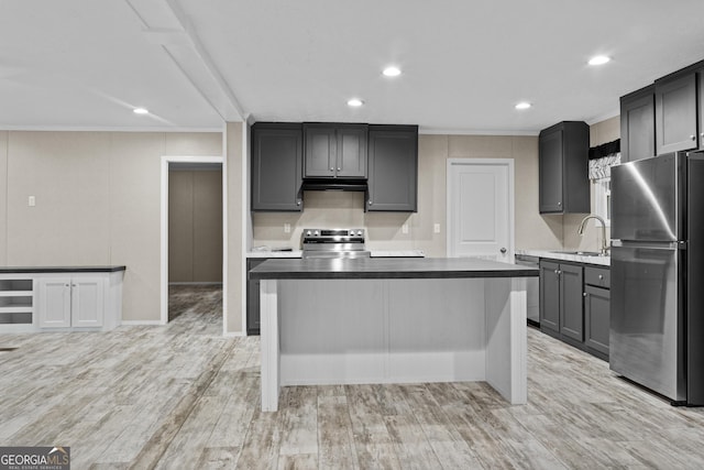 kitchen featuring a center island, stainless steel appliances, gray cabinetry, light wood-style floors, and a sink