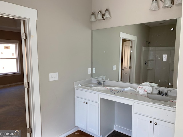 full bathroom with double vanity, baseboards, walk in shower, and a sink