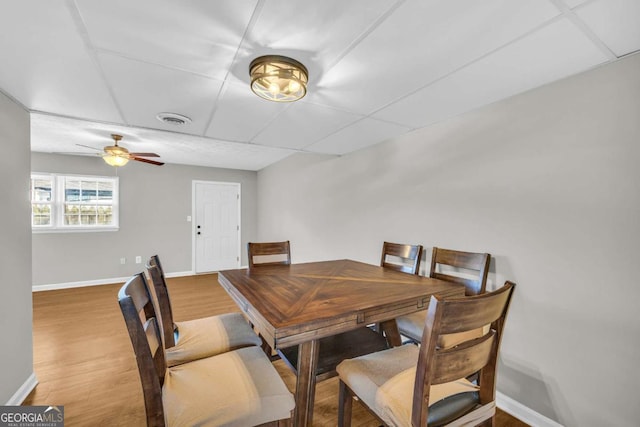 dining space featuring wood finished floors, visible vents, and baseboards